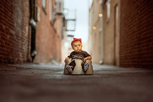 baby in a car seat in an alley